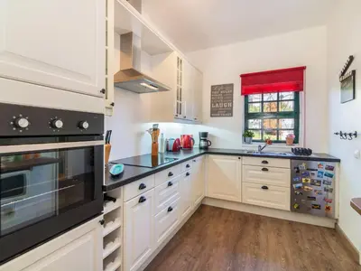 a kitchen with white cabinets and black appliances at Holiday Home Roberts by Interhome in Albufeira