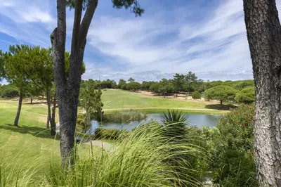 a golf course with a pond and trees at Walkable Marina Vilamoura Aquamar 513 VilamouraSun in Quarteira