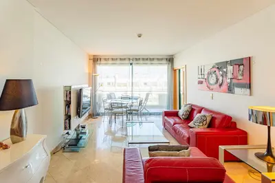 a living room with a red couch and a table at Walkable Marina Vilamoura Aquamar 513 VilamouraSun in Quarteira