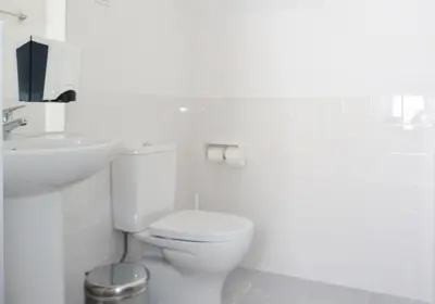 a white bathroom with a toilet and a sink at Peneco Albufeira GuestHouse in Albufeira