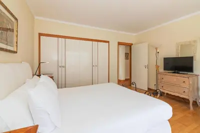 a bedroom with a white bed and a television at Apartamento dentro da Marina de Vilamoura in Vilamoura
