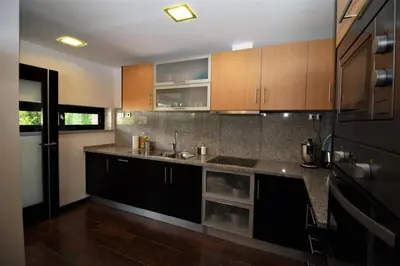 a kitchen with brown cabinets and a black refrigerator at Townhouse 3 Bedroom Townhouse Olhos de Agua Communal pool AT03 in Olhos de Água