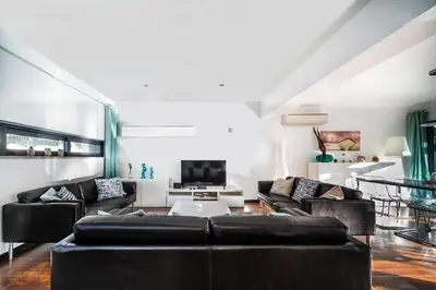 a living room with black leather couches and a tv at Townhouse 3 Bedroom Townhouse Olhos de Agua Communal pool AT03 in Olhos de Água