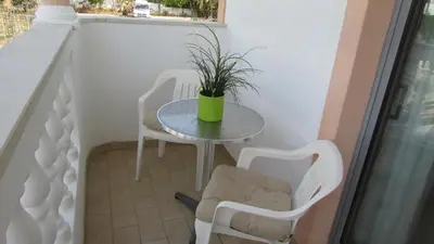 a small table and chairs on a balcony at Apartamento - 2 a 4 Pessoas- Piscina in Olhos de Água