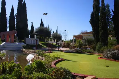 a green yard with trees and a pond at Marina Vilamoura Aquamar 203 By Vilamoura Sun in Quarteira