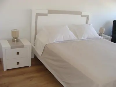 a bedroom with a white bed and a night stand at Casa do Largo in Faro