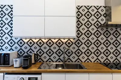 a kitchen with a sink and black and white tiles at Faro Guest House in Faro
