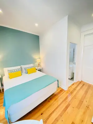 a bedroom with a blue and white bed and wooden floors at Faro Guest House in Faro