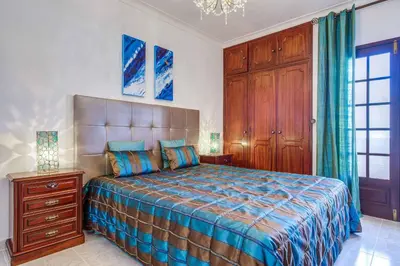 a bedroom with a bed and a wooden cabinet at Villa Antao in Guia