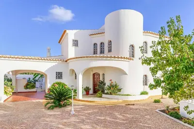a large white house with a courtyard at Villa Antao in Guia