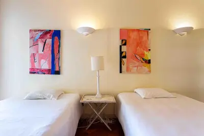 two beds in a room with paintings on the wall at Luxury Villa 6 bedrooms with private pool in Vilamoura
