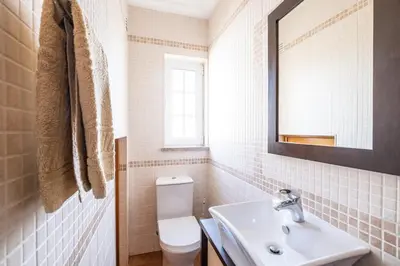a bathroom with a white toilet and a sink at Villa Isabella in Albufeira
