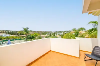 a room with a balcony with a chair at Villa Isabella in Albufeira