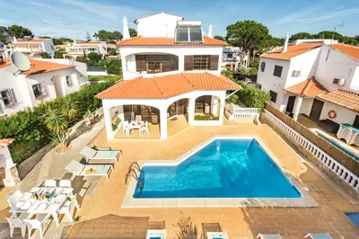 a bedroom with two beds and two windows at Spacious 4 bedroom villa, private pool, free air conditioning and wifi in Quarteira