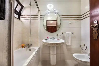 a white bathroom with a sink and a toilet at Spacious 4 bedroom villa, private pool, free air conditioning and wifi in Quarteira