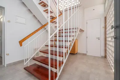 a wooden staircase in a home with white walls at Sundance Beach House in Faro