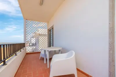a balcony with a white table and a white chair at Sundance Beach House in Faro