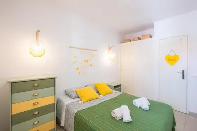 a bedroom with a bed with yellow and green sheets at #006 Foxy D by Home Holidays in Albufeira