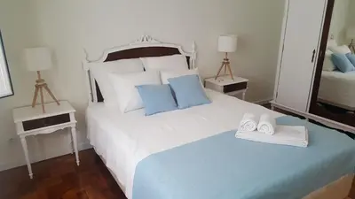 a bedroom with a large white bed with blue pillows at Casa aOrta Downtown in Faro
