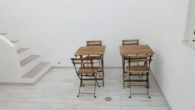 two wooden stools sitting next to a white wall at Casa aOrta Downtown in Faro