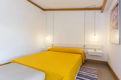 a bedroom with a yellow bed and a rug at 1Bed Apart Quinta do Lago in Almancil