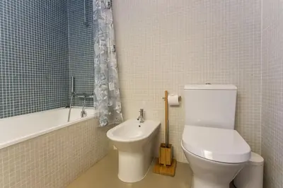 a bathroom with a toilet and a tub and a sink at 1Bed Apart Quinta do Lago in Almancil