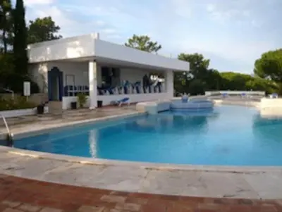 a large swimming pool in front of a house at 1Bed Apart Quinta do Lago in Almancil