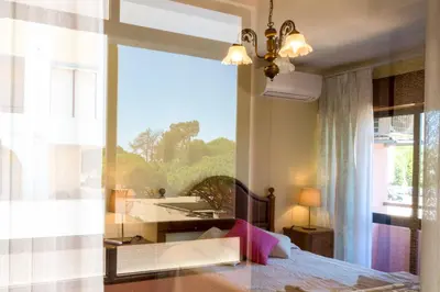 a bedroom with a bed and a large window at Apartamento São Pedro do Mar in Quarteira