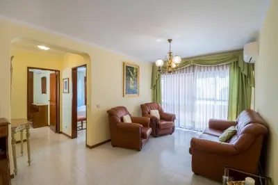 a living room with leather chairs and a couch at Apartamento São Pedro do Mar in Quarteira