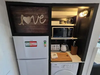 a small kitchen with a refrigerator and a microwave at Love Albufeira - Center, walk to the beach, Old Town, Oura Strip, top location in Albufeira