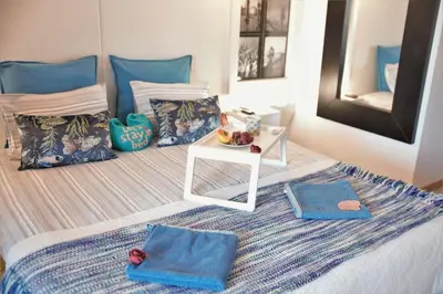 a bedroom with a bed with blue pillows and a table at Love Albufeira - Center, walk to the beach, Old Town, Oura Strip, top location in Albufeira