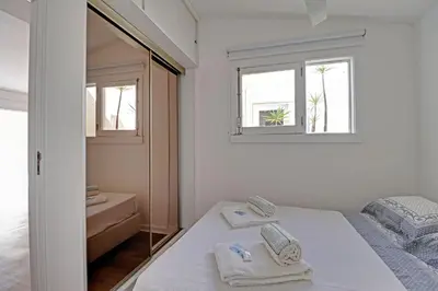a white room with a bed and two windows at Vilamoura Golf Villa 1 With Pool by Homing in Vilamoura
