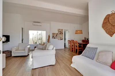 a living room with white furniture and a kitchen at Vilamoura Golf Villa 1 With Pool by Homing in Vilamoura