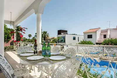 a villa with a swimming pool with chairs and an umbrella at Charming Villa With Private Pool in Vibrant Vilamoura, Free AC and Wifi in Quarteira
