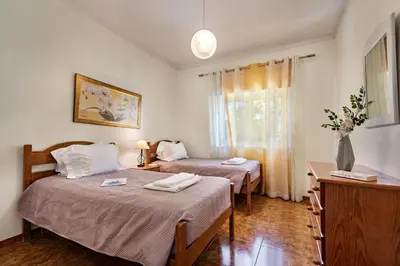 a kitchen and dining room with a wooden table and chairs at Charming Villa With Private Pool in Vibrant Vilamoura, Free AC and Wifi in Quarteira