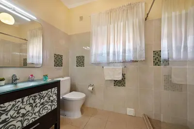 a white bathroom with a sink and a mirror at Charming Villa With Private Pool in Vibrant Vilamoura, Free AC and Wifi in Quarteira