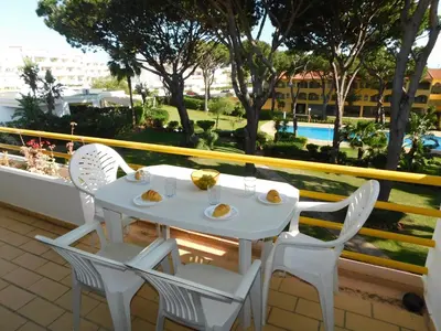 a balcony with a table and some plants at Sol Nascente Garden in Vilamoura