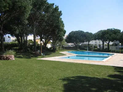 a swimming pool in a yard with grass and trees at Sol Nascente Garden in Vilamoura
