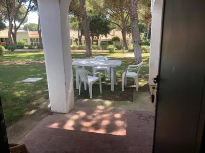 a white table and chairs in a yard with trees at Studio - Praia da Falesia - Algarve in Albufeira