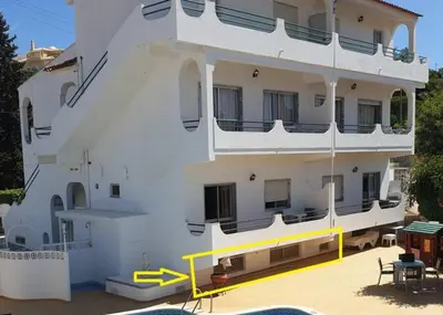 a large white building with a yellow railing in front of it at AAA Awesome Apartamentos Albufeira in Albufeira
