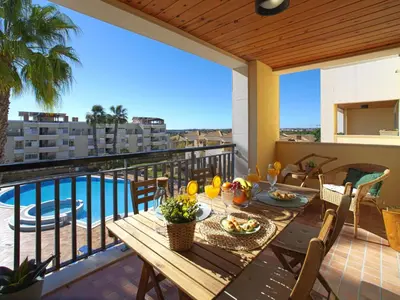 a table on a balcony with a view of a pool at Apartment Vilas Mouriscas by Interhome in Vilamoura