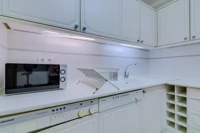 a kitchen with white cabinets and a microwave at Varandas do Sul - Near Vilamoura Marina in Vilamoura