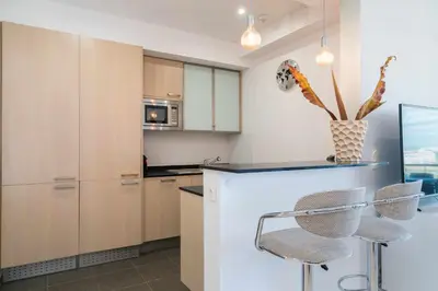 a kitchen with white cabinets and a table and chairs at Vilamoura Sun Aquamar 503 in Quarteira
