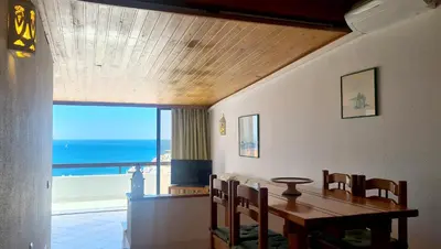 a dining room with a table and a view of the ocean at Albufeira, One step to the beach (13) in Albufeira