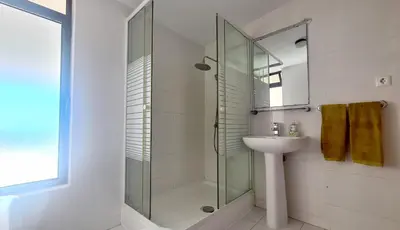 a bathroom with a glass shower and a sink at Albufeira, One step to the beach (13) in Albufeira