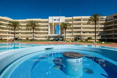 a swimming pool in front of a large building at VR Galé Mar in Albufeira