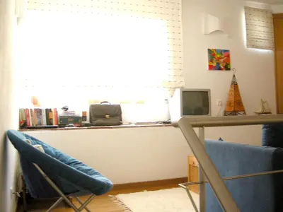 a living room with a desk and a blue chair at Welcoming House in Albufeira in Albufeira