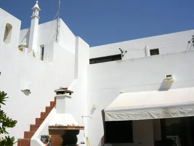 a white building with a steeple and stairs at Welcoming House in Albufeira in Albufeira