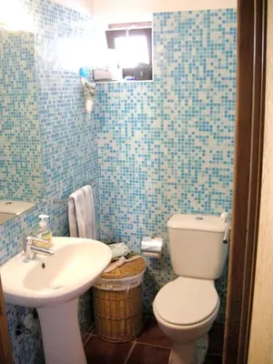 a blue tiled bathroom with a toilet and a sink at Welcoming House in Albufeira in Albufeira
