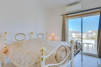 a white bed in a bedroom with a balcony at Falésia II - Nice Apartment - Vilamoura in Vilamoura